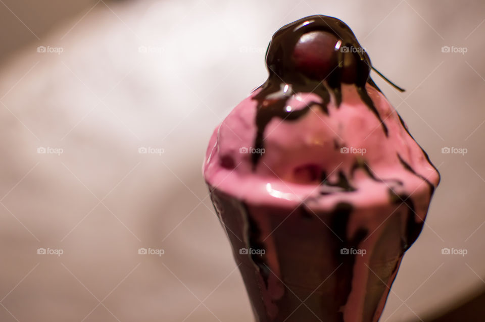 Luxurious dark chocolate draped over black cherry on top of melting pink ice cream beautiful real food messthetics  photography 