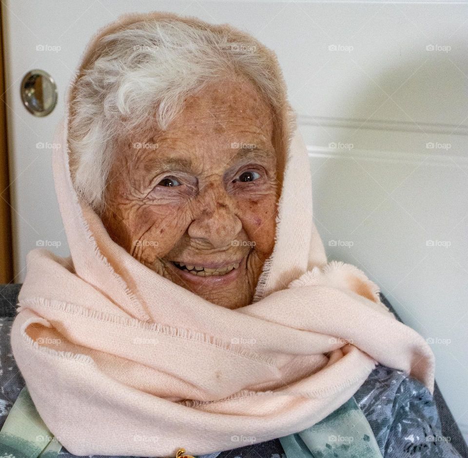 Old woman ,2 years from hundred years old . ,with scarf at her head. 
smiling and happy ,2 years from hundred