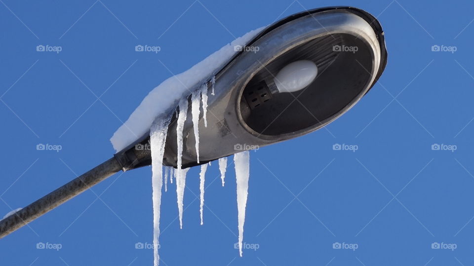 Low angle view of icicles hanging on streetlight
