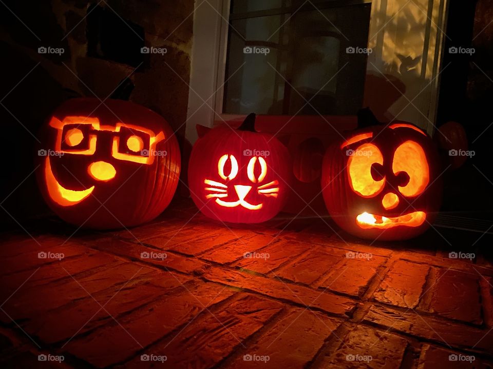 Jack-o-lanterns at night with candles pumpkin carving funny faces