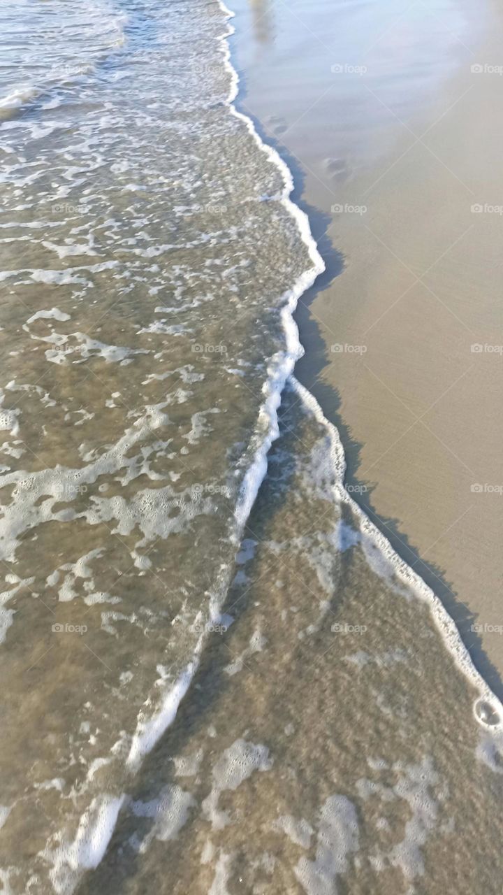 Wave touching sand on the beach