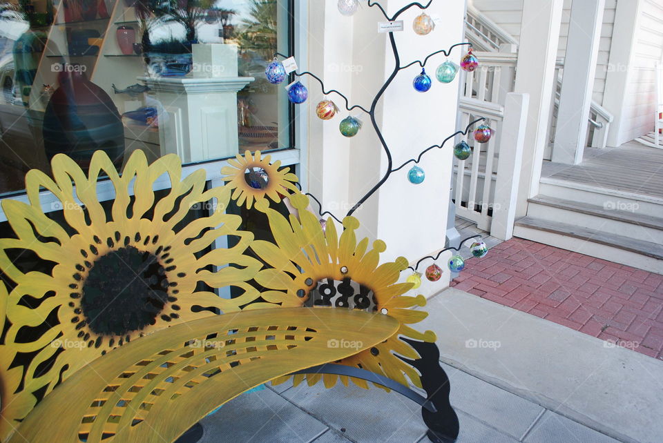 A yellow bench in front of a store