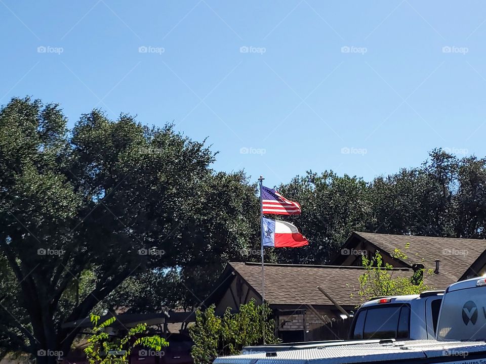 American flag in a residential area along side a Texas fly