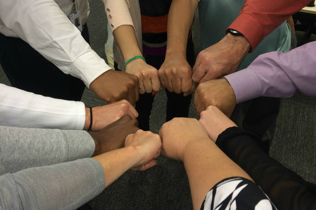 All hands in. Team pow wow before a major project.