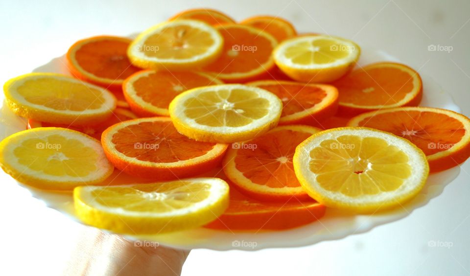 orange citrus fruits on a plate in the hand white background