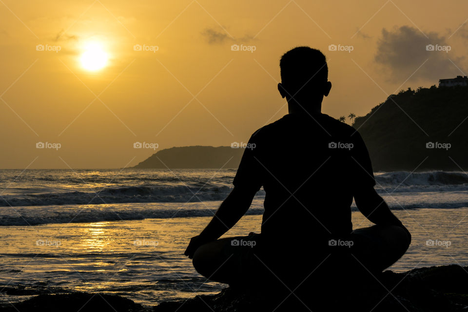 Meditation on a beach at sunset