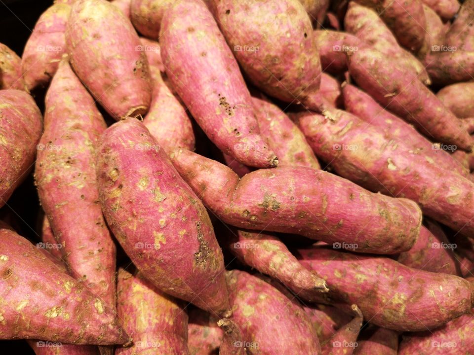 Close-up of a lot of sweet potatoes. A lot of yams.