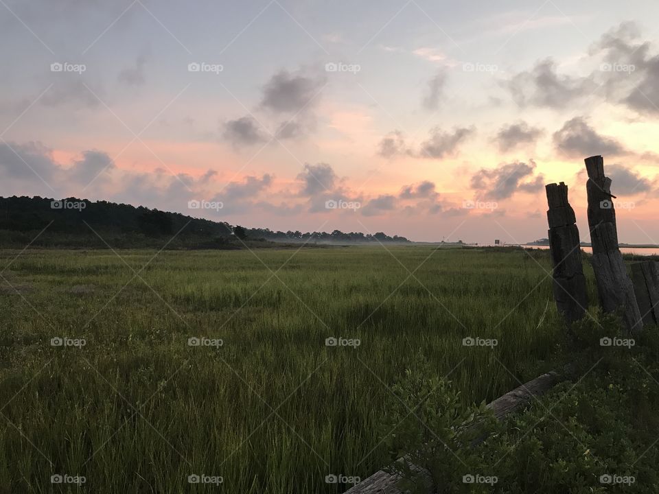 Beginning of a sunrise over a marsh.