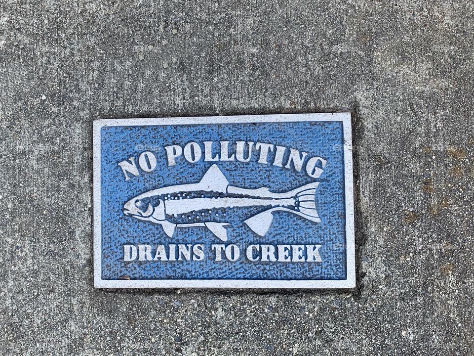 Sewer Sign reading No polluting drains to creek - fish USA, America 