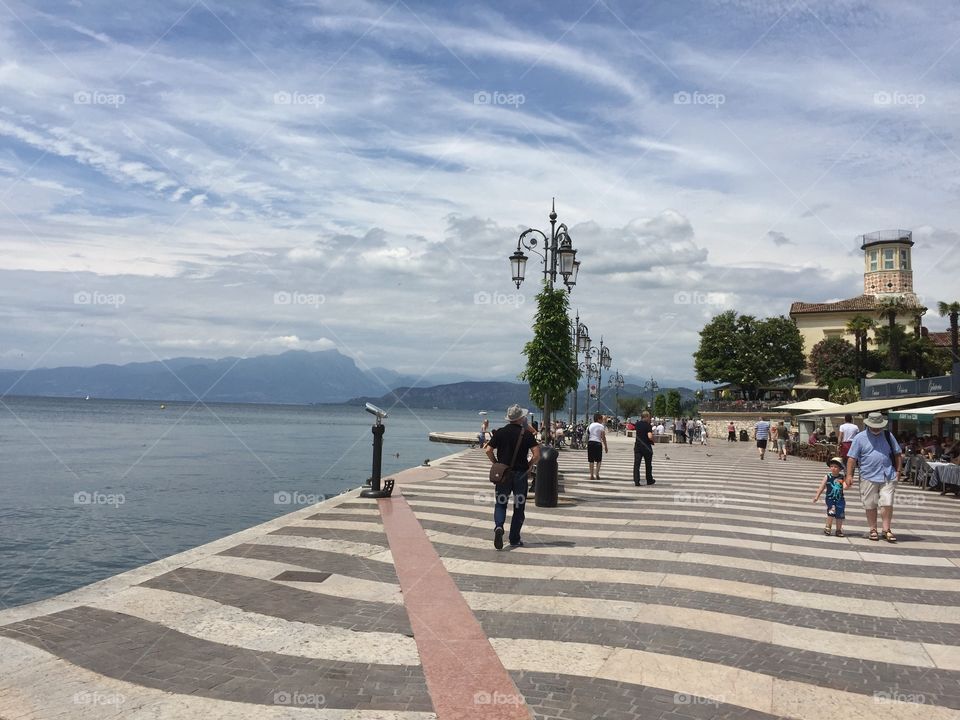 Walking along the promenade of Lazise on a sunny day - Lake Garda, Italy