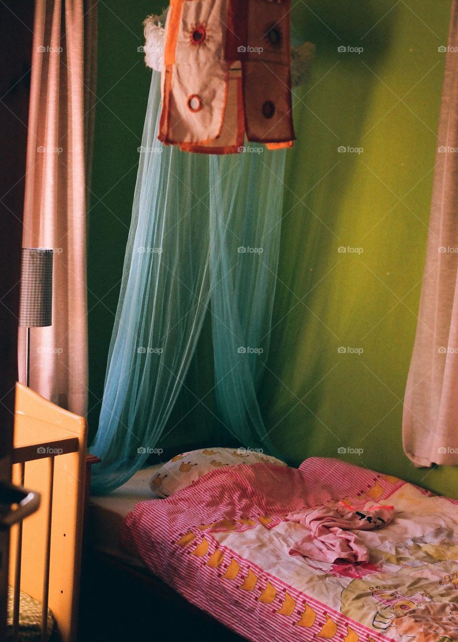 Colorful corner in a bedroom for children, bright colours as blue and pink. Cosy bed. Curtains, children room