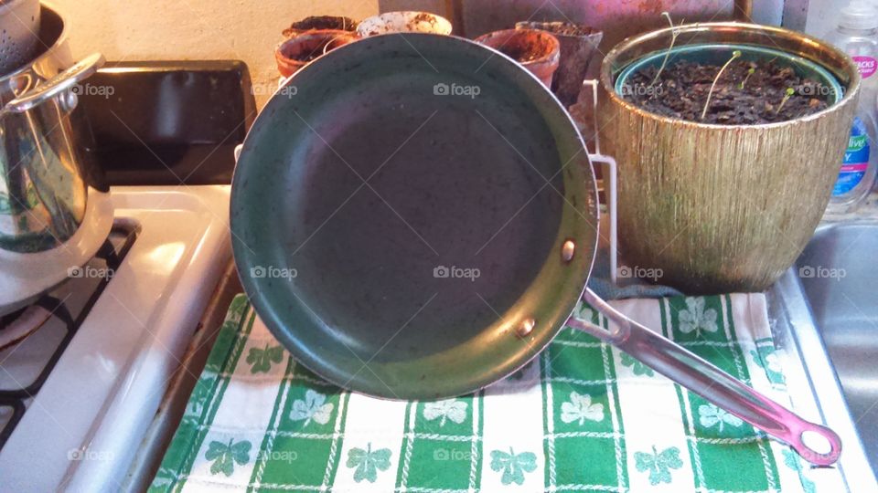 Green ceramic frying pan with St Patrick's day kitchen towel