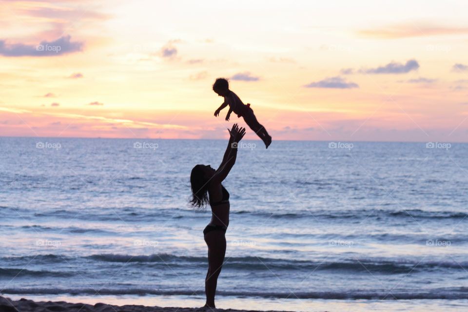 Mother with a baby enjoy sunset 
