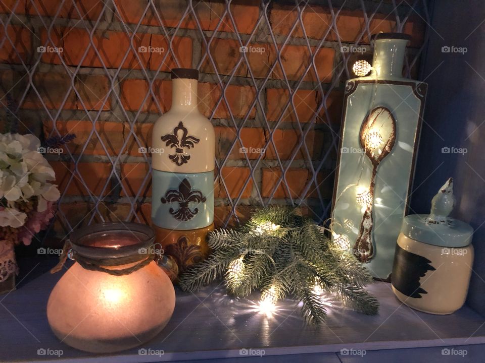 Winter interior design with lights, bottles, candle and green tree
