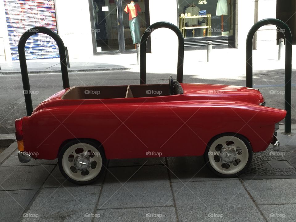 Small red toy car in a parking lot 