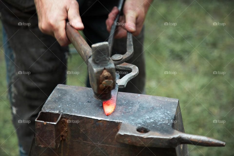 Close up view of heated metal and anvil.