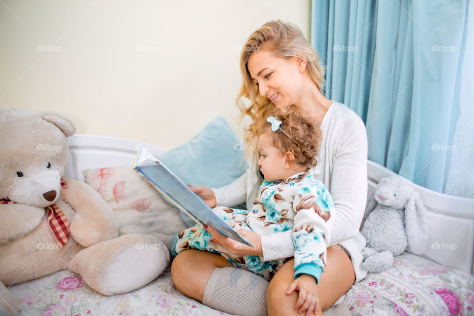 Mother with daughter reading a book