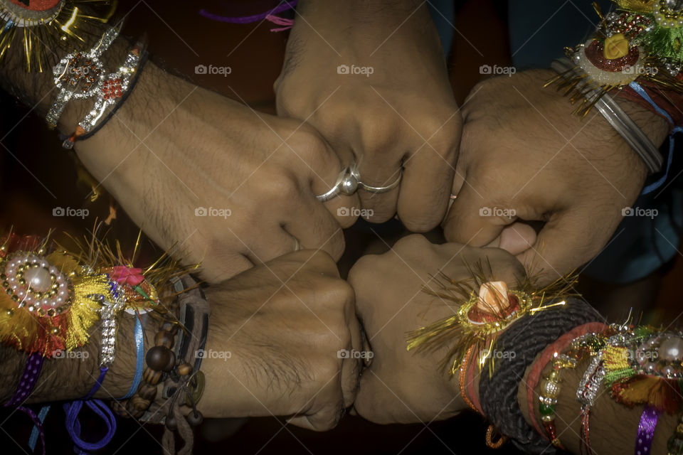 Close up hand fist of human boys friends waring friendship band on arms. Teamwork confident togetherness positivity expression celebration and spirit gesture. Team unity united hands together concept