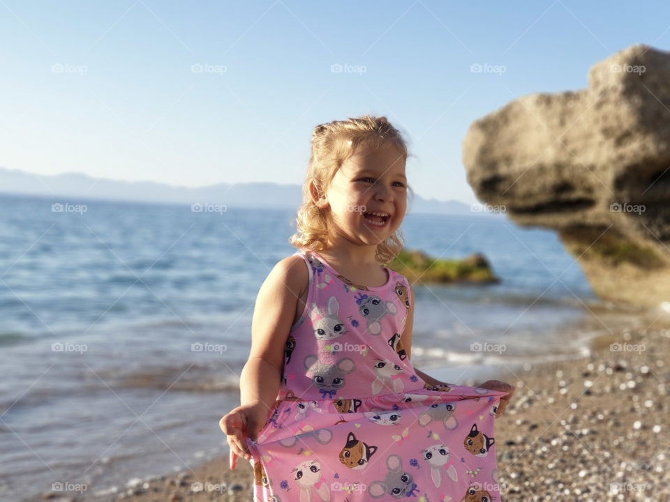 Little girl full of joy on the beach
