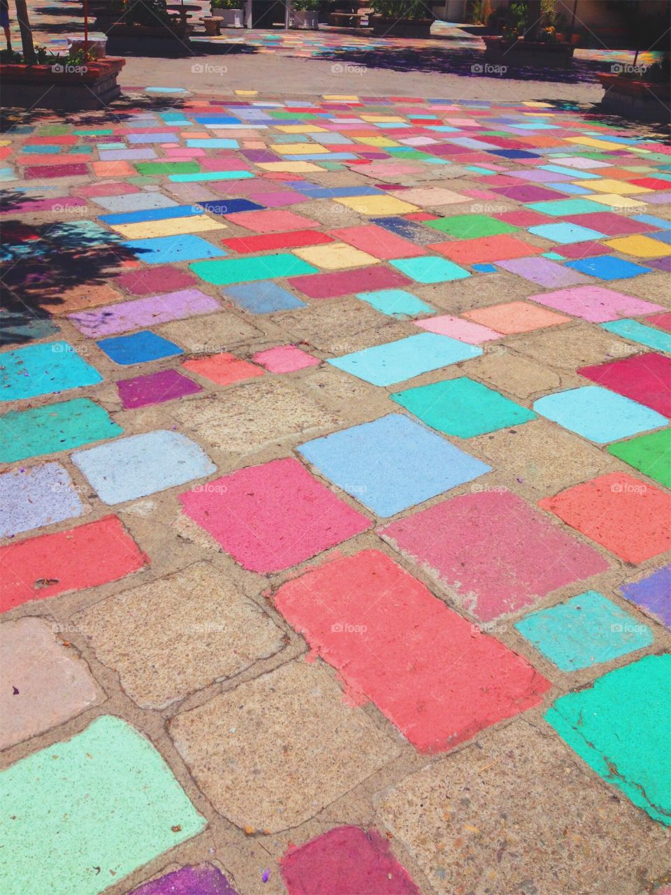 Colorful cobblestone path in San Diego leading to a local marketplace near the zoo. Beautiful colors on a sunny day with hints of shadows from the trees.