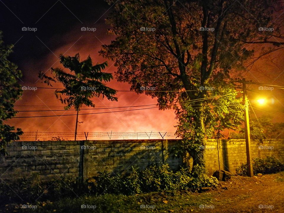 A scary scenery showing big fire over the fence.