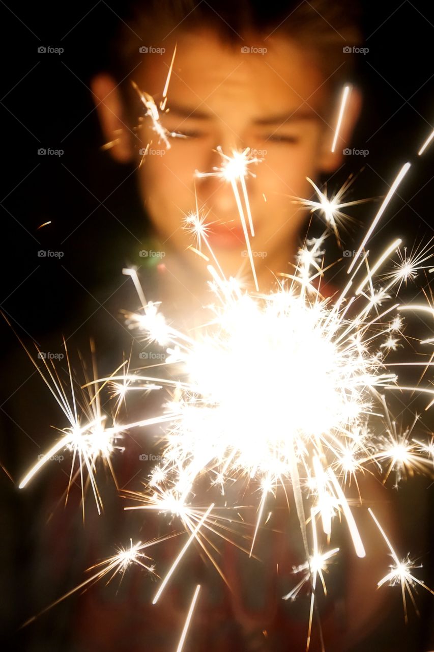 Boy hand holding sparkler