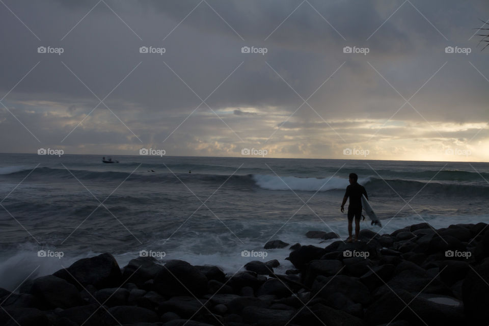 Surfer heading out at dawn 