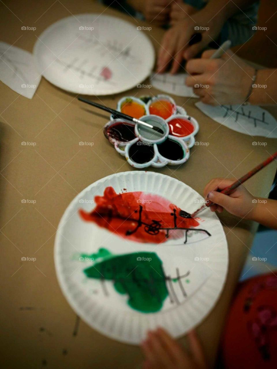 A young child adds color to her autumn leaves.