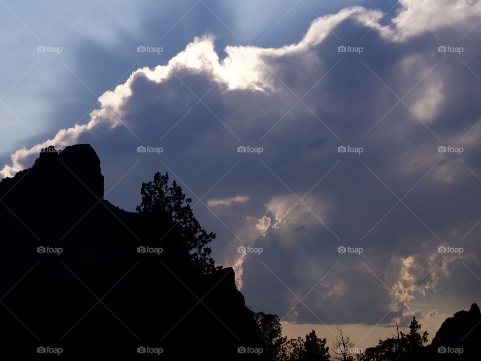 Beautiful sun rays break through the clouds after an evening summer rain storm at Smith Rocks in Central Oregon. 