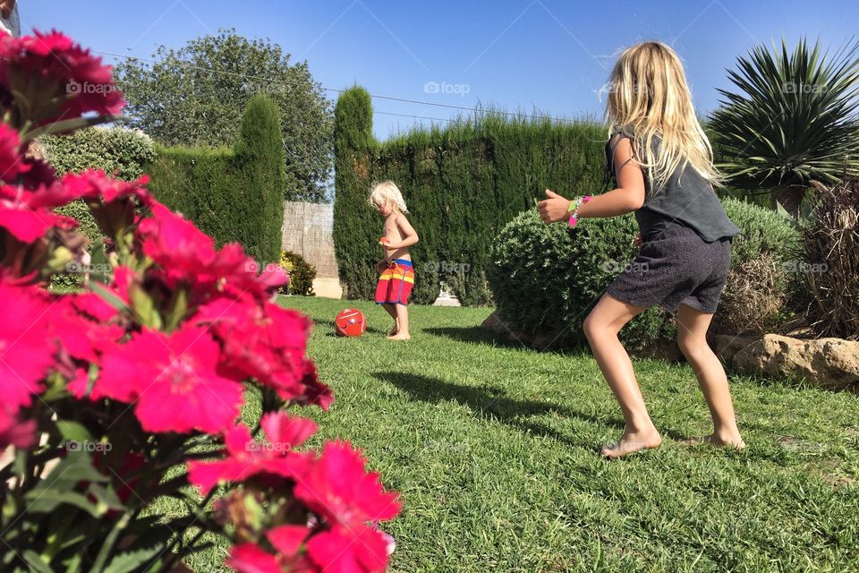 Kids playing football in a garden 
