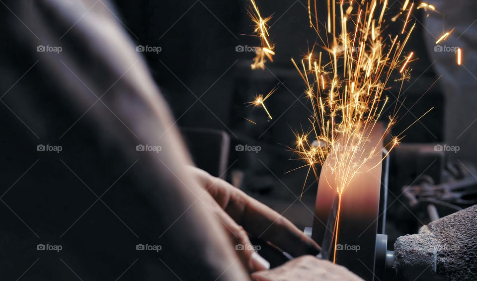 sparks made by using electric disc grinder polishing the surface metal