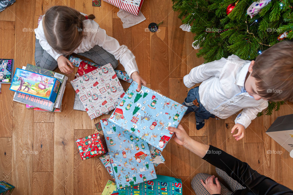 Celebrating Christmas Eve with gifts. Children getting theirs presents.