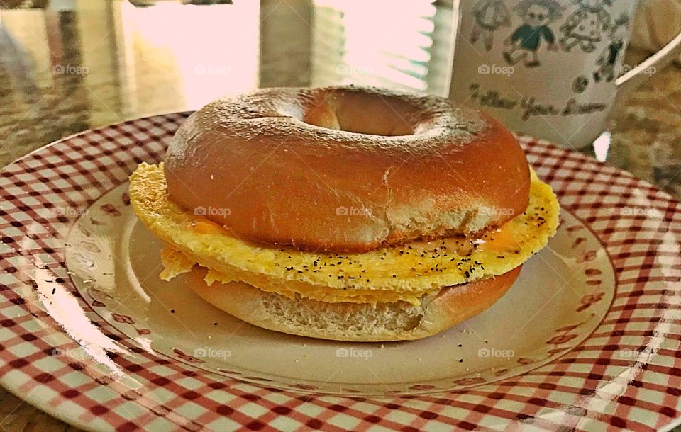 Breakfast sandwich, scrambled eggs and cheese on a bagel 