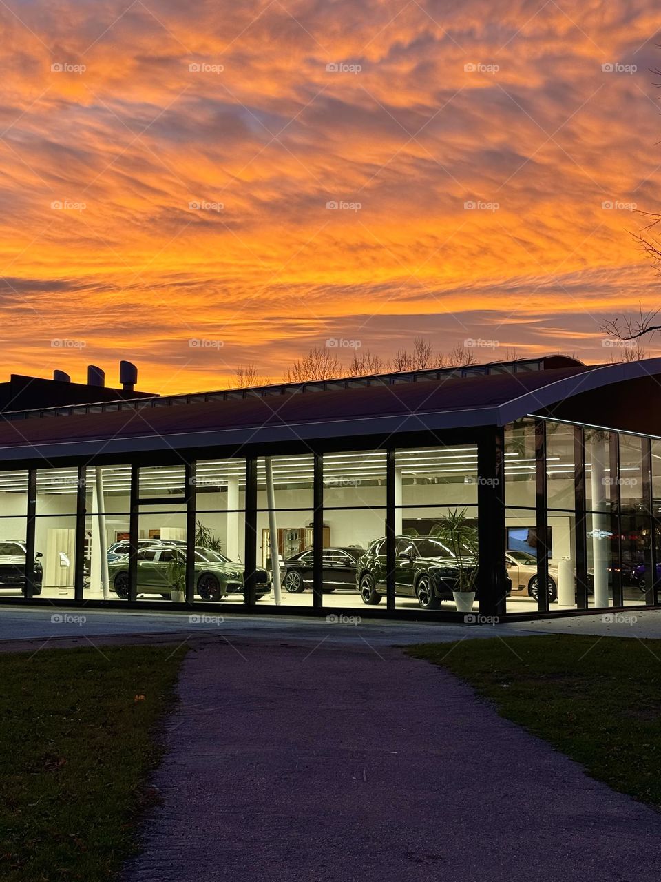 view of the car dealership from the street, beautiful sunset cloudy sky