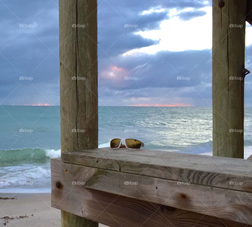 Ocean. Sunglasses. Dock. Sand. Pastel color. Sky. Morning. Dawn. 