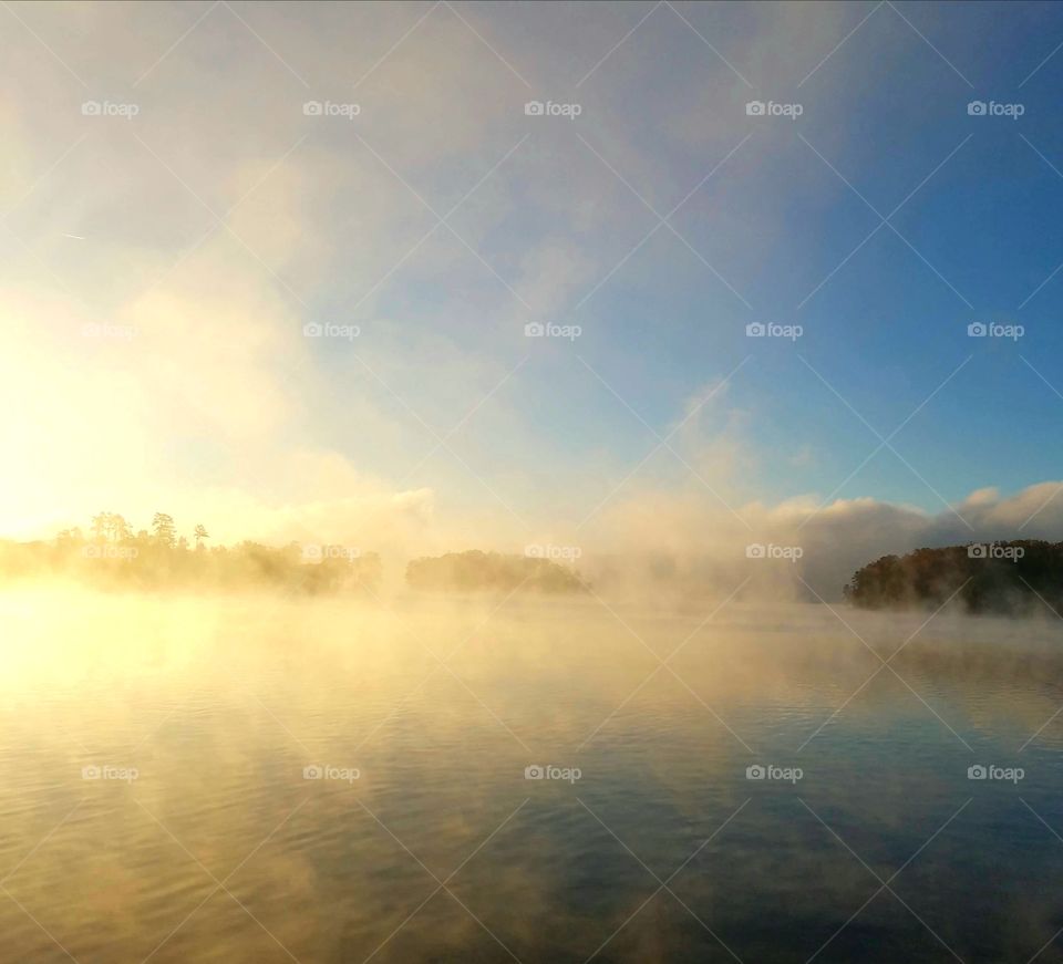 foggy morning.
blue skies above island.