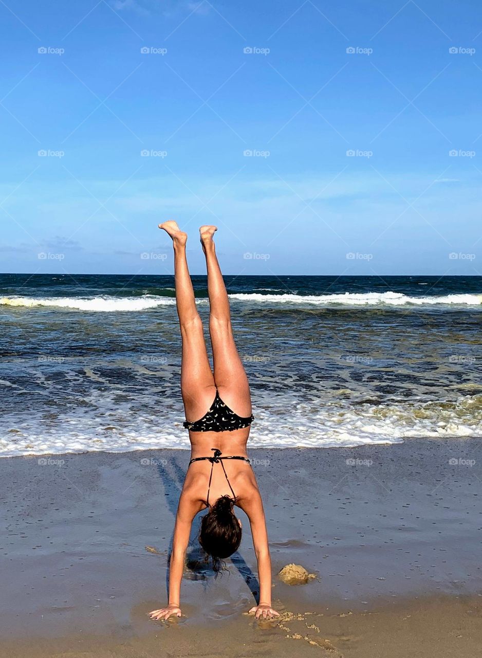 Child doing acrobatics on the beach