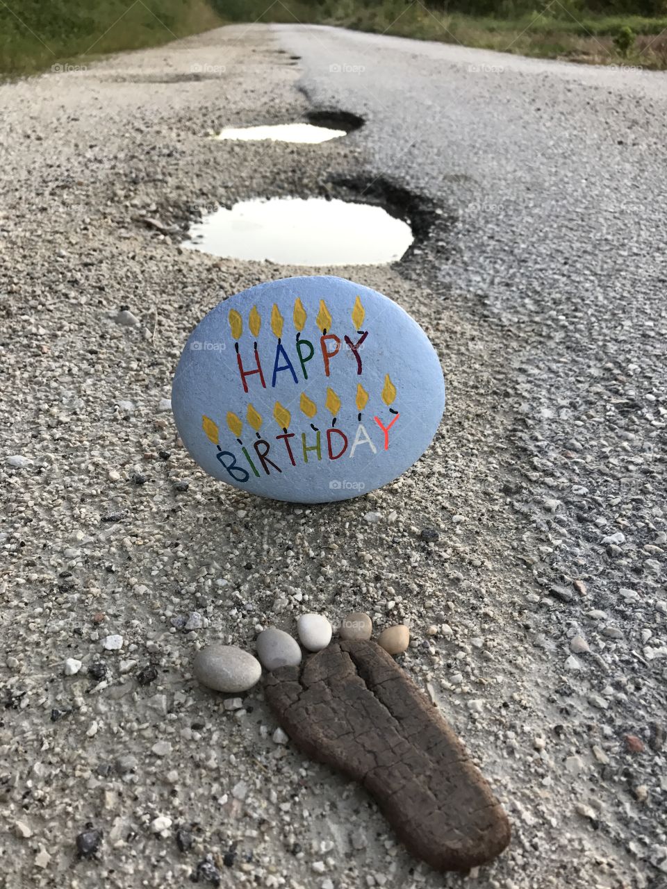 Happy Birthday stone on a country road 