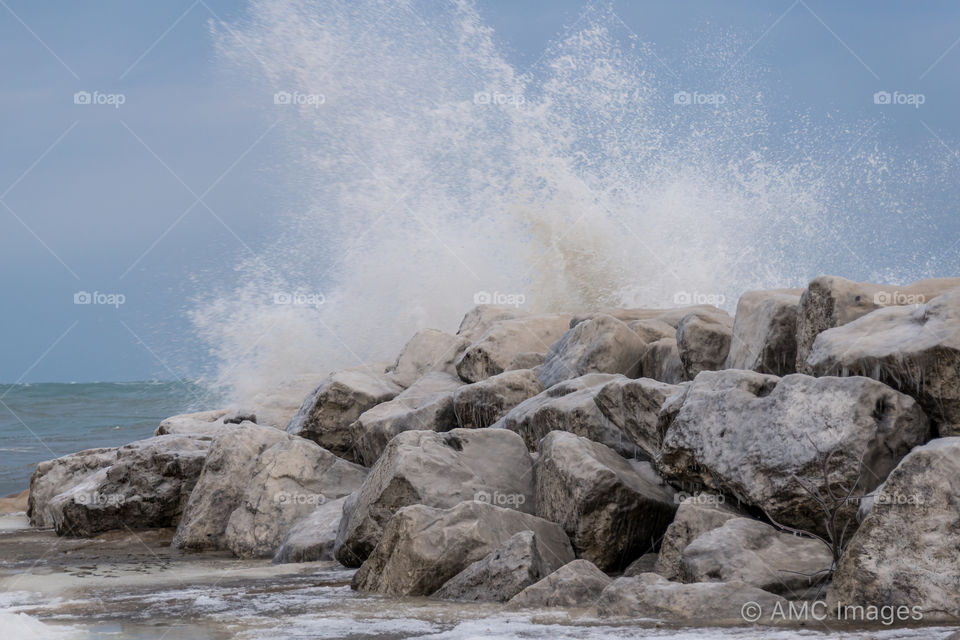 Waves crashing against large rocks on the shore of Lake Michigan in Milwaukee, Wisconsin