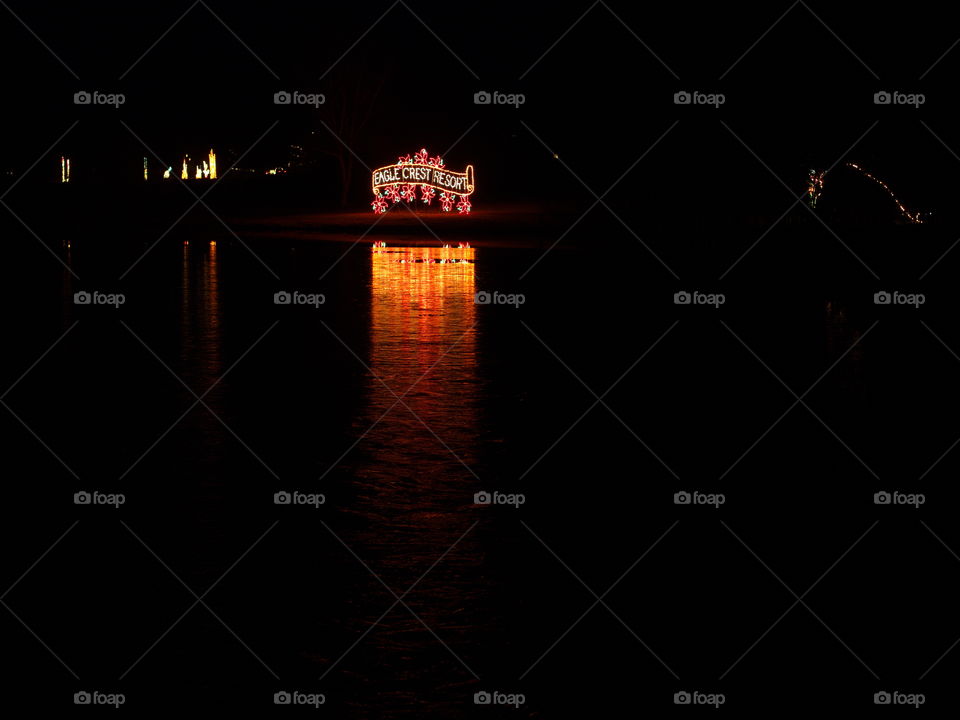 The Christmas display of a sign reflects in a frozen pond on a cold winter night at Eagle Crest Resort in Central Oregon. 