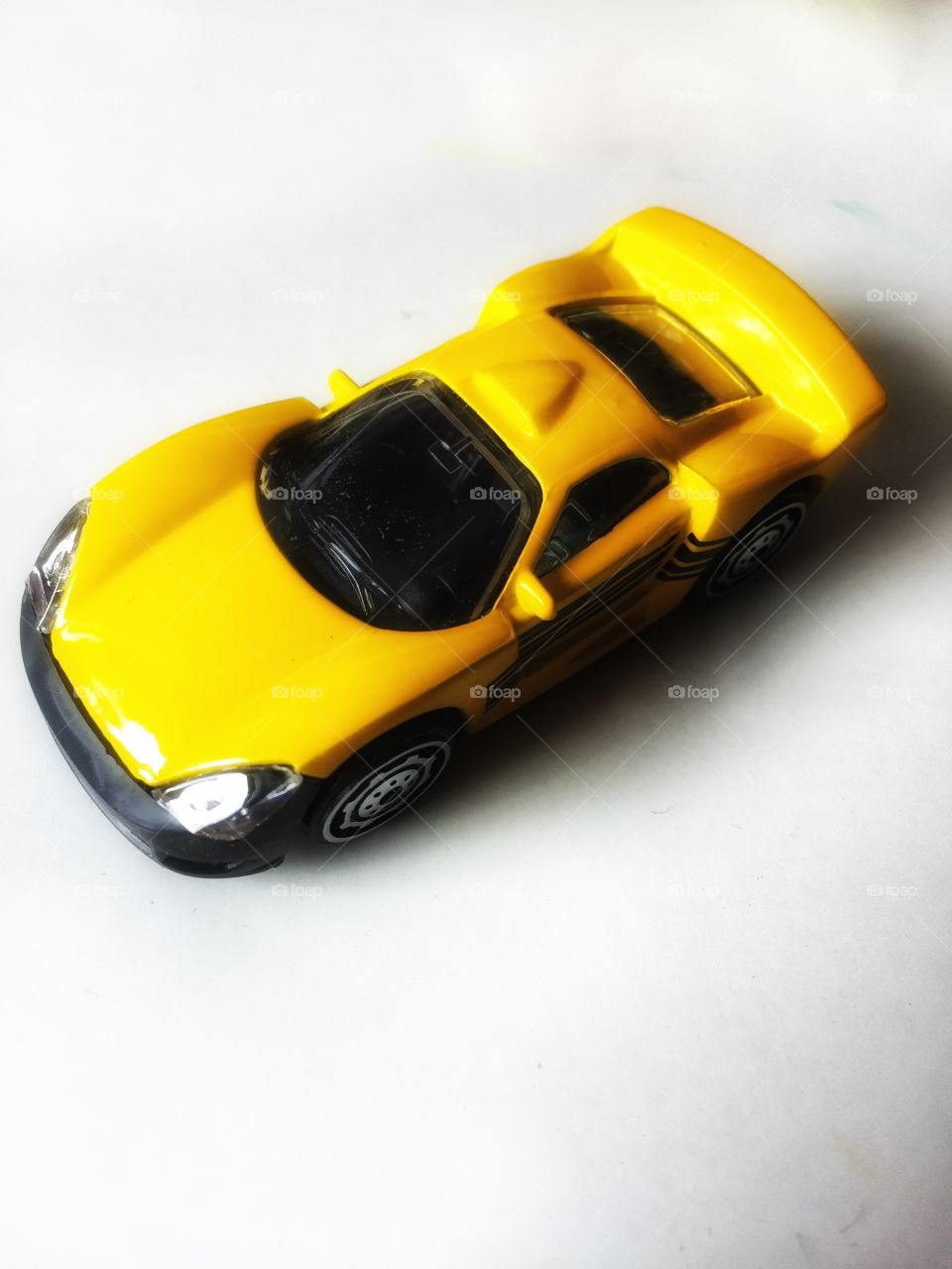 Yellow toy sports car on white background 