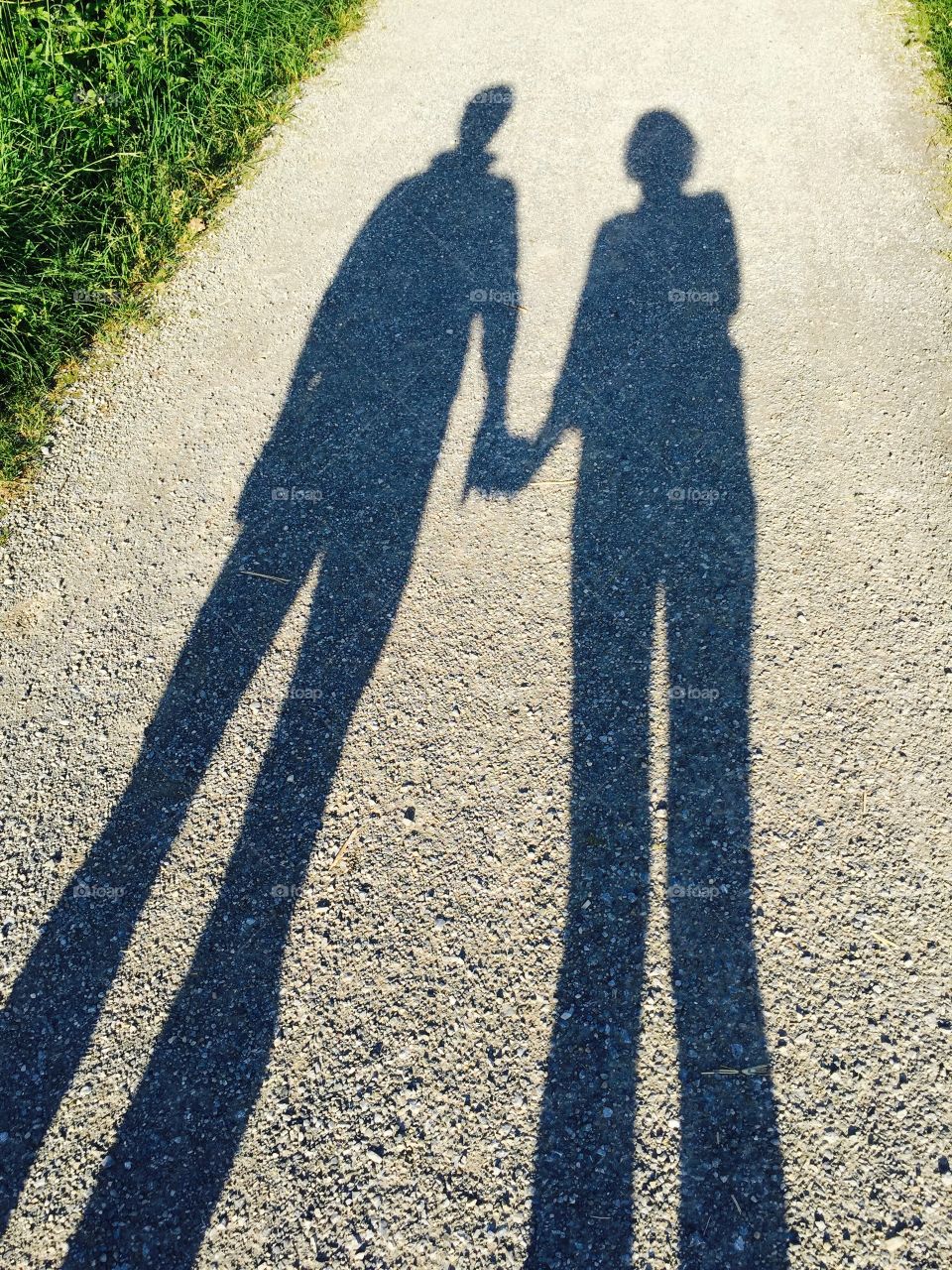 Shadow couple in love. Shadow couple walks hand in hand on a sunny day
