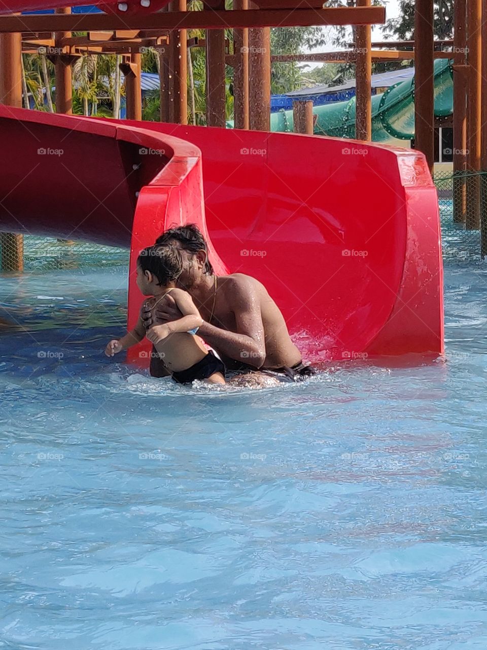 father and son having fun time in a water park in summer vacation