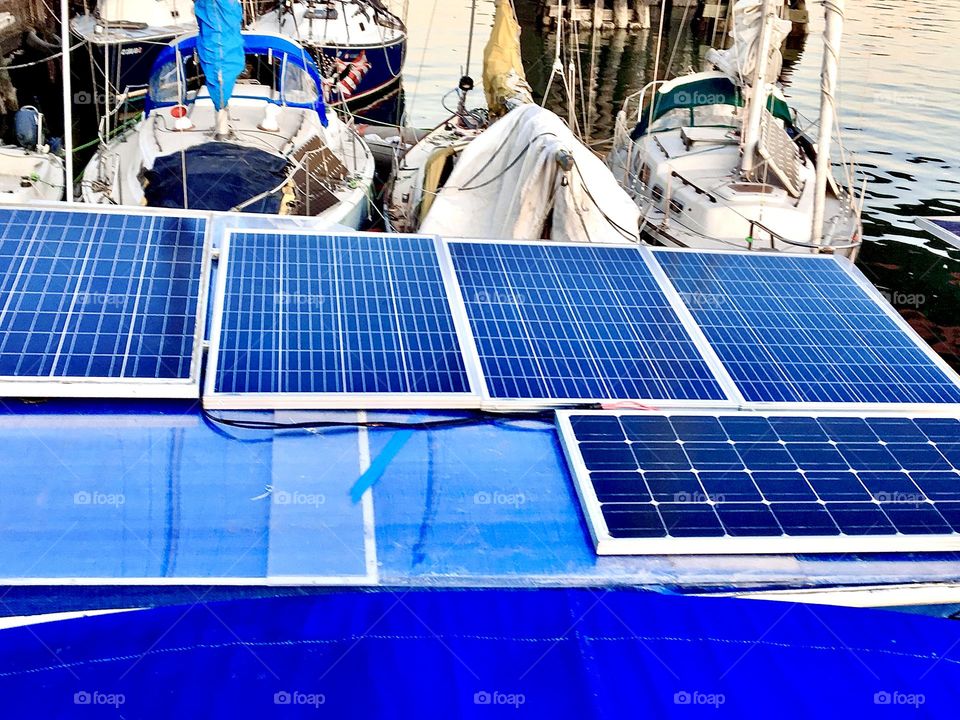Solar panels closely together filling the entire available surface on the rooftop of our boat, the “Salvation” in the waters of the East River at Newtown Creek in Long Island City, Queens, NY help us power our appliances. 2021. Hypnotic Productions