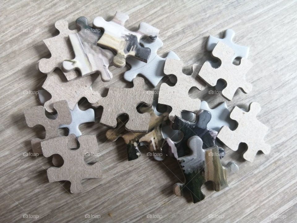Puzzles are scattered on the floor of gray boards