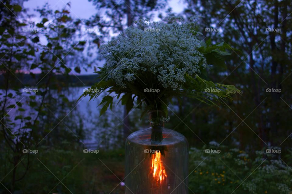 Midsummer bonfire shot through flower vase full of water. St. John's eve bonfire captured through flower vase.