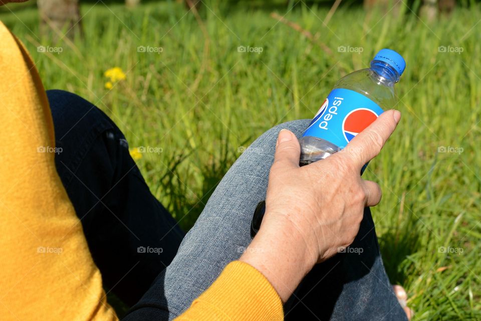 Pepsi in the female hand green background