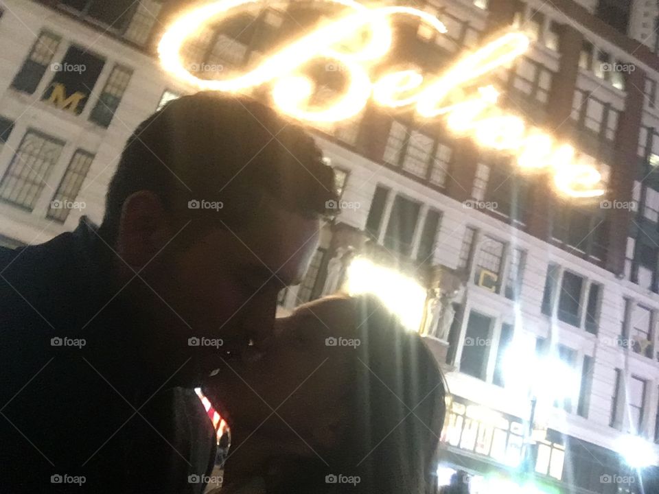 A couple in front of the Macy’s “believe” sign in New York City during the Holiday season.