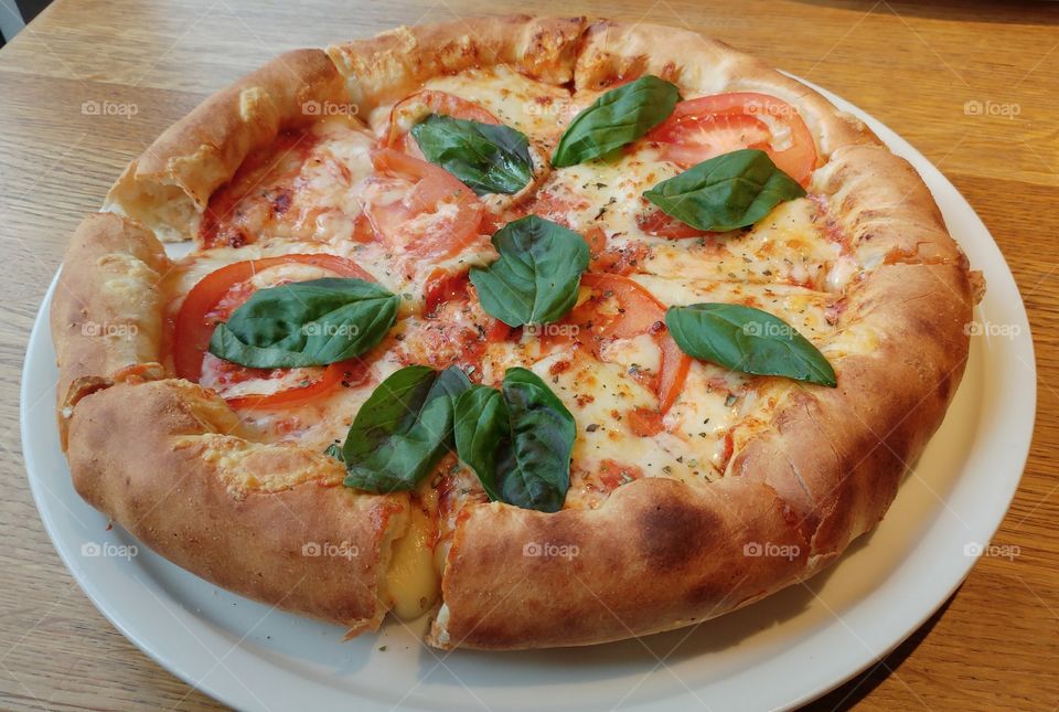 A stuffed-crust pizza topped with mozzarella, tomatoes and basil.
