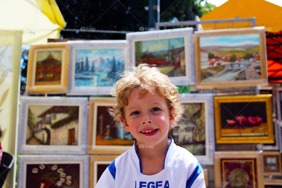 Boy posing next to art display 